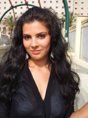 Siyah elbiseli güzel bir esmerin portresi.