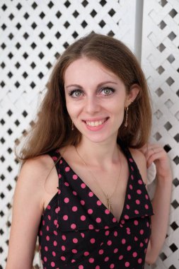 Genç kız gülümsüyor ve kameraya bakıyor. Genç bir kızın portresi