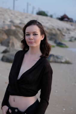 Akşamları deniz kıyısında poz veren güzel kız.