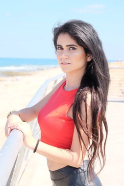 Kumsalda kırmızı bikinili güzel bir kadın.