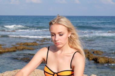 Kumsalda mayo giymiş güzel bir kadın..