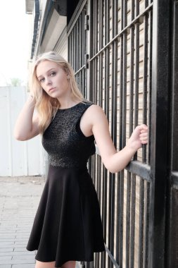 Sarışın bir model şehir ortamında poz veriyor.