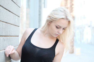 Sokakta beyaz elbiseli güzel sarışın bir kadın.