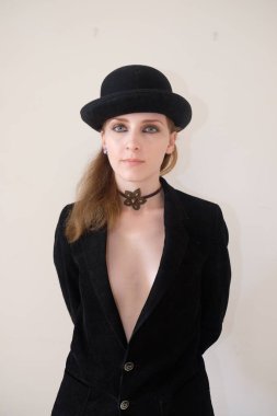 Siyah şapkalı ve kravatlı güzel bir kızın portresi.