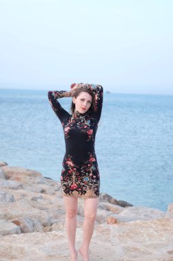 Akşamları kumsalda poz veren bir kız.