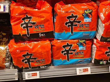 Hong Kong, Çin - 23 Nisan 2025: Popüler Kore Nongshim Shin Ramyun hazır erişte çoklu paketleri, orijinal ve karides aromalı, süpermarket rafında istiflenmiş.