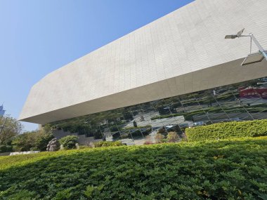 Shenzhen, Çin - 17 Ocak 2025: MOCAPE 'in ikonik' Bulut 'heykeli modern müze alanını keşfeden ziyaretçilerle birlikte geniş geometrik tavan penceresini yansıtıyor.