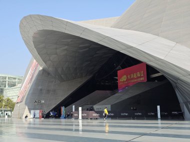 Shenzhen, Çin - 17 Ocak 2025: MOCAPE 'in ikonik' Bulut 'heykeli modern müze alanını keşfeden ziyaretçilerle birlikte geniş geometrik tavan penceresini yansıtıyor.