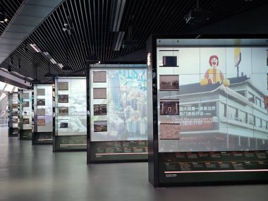 Shenzhen, Çin - 17 Ocak 2025: MOCAPE 'in ikonik' Bulut 'heykeli modern müze alanını keşfeden ziyaretçilerle birlikte geniş geometrik tavan penceresini yansıtıyor.