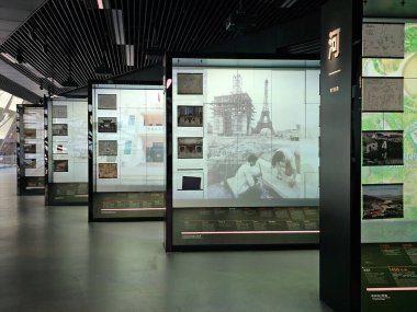 Shenzhen, Çin - 17 Ocak 2025: MOCAPE 'in ikonik' Bulut 'heykeli modern müze alanını keşfeden ziyaretçilerle birlikte geniş geometrik tavan penceresini yansıtıyor.