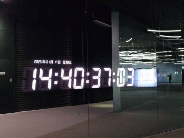 Shenzhen, Çin - 17 Ocak 2025: MOCAPE 'in ikonik' Bulut 'heykeli modern müze alanını keşfeden ziyaretçilerle birlikte geniş geometrik tavan penceresini yansıtıyor.