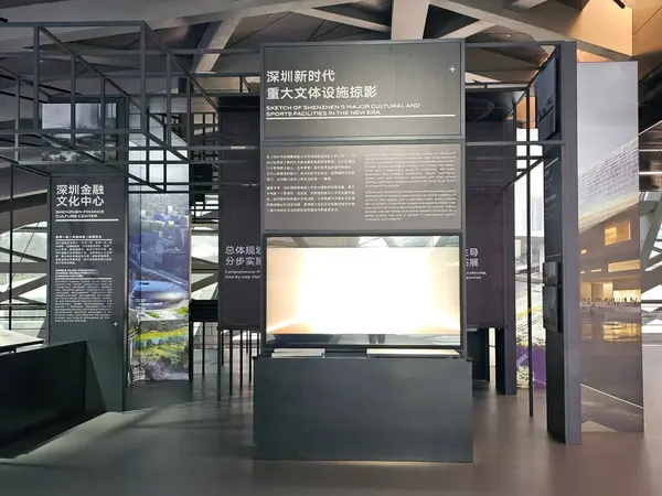 Shenzhen, Çin - 17 Ocak 2025: MOCAPE 'in ikonik' Bulut 'heykeli modern müze alanını keşfeden ziyaretçilerle birlikte geniş geometrik tavan penceresini yansıtıyor.