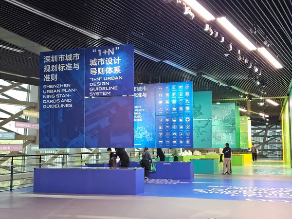 Shenzhen, Çin - 17 Ocak 2025: MOCAPE 'in ikonik' Bulut 'heykeli modern müze alanını keşfeden ziyaretçilerle birlikte geniş geometrik tavan penceresini yansıtıyor.