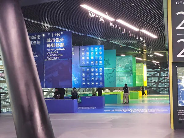 Shenzhen, Çin - 17 Ocak 2025: MOCAPE 'in ikonik' Bulut 'heykeli modern müze alanını keşfeden ziyaretçilerle birlikte geniş geometrik tavan penceresini yansıtıyor.