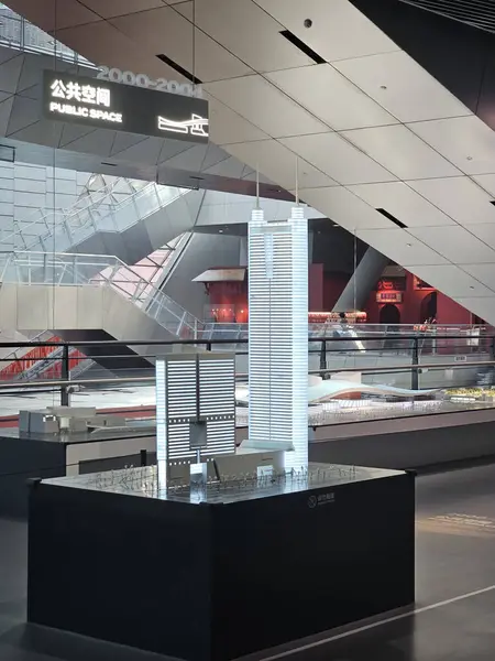 Shenzhen, Çin - 17 Ocak 2025: MOCAPE 'in ikonik' Bulut 'heykeli modern müze alanını keşfeden ziyaretçilerle birlikte geniş geometrik tavan penceresini yansıtıyor.