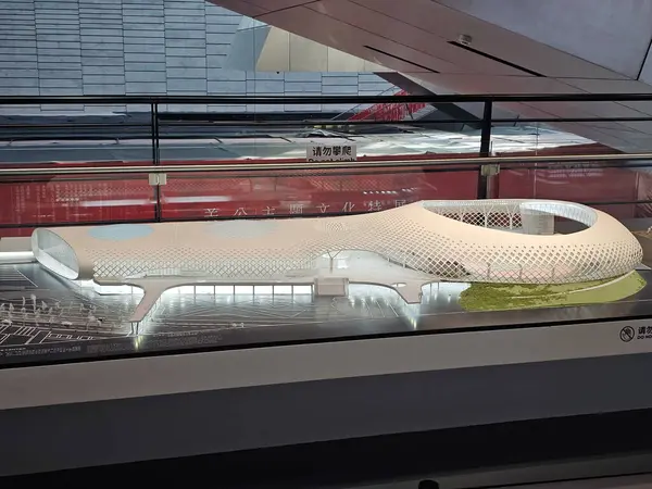 Shenzhen, Çin - 17 Ocak 2025: MOCAPE 'in ikonik' Bulut 'heykeli modern müze alanını keşfeden ziyaretçilerle birlikte geniş geometrik tavan penceresini yansıtıyor.