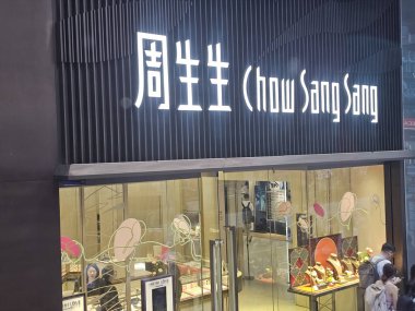 Hong Kong, Çin - 6 Haziran 2025: Chow Sang kuyumcu cephesi, şık vitrininde lüks altın ve elmas parçaları sergileniyor..