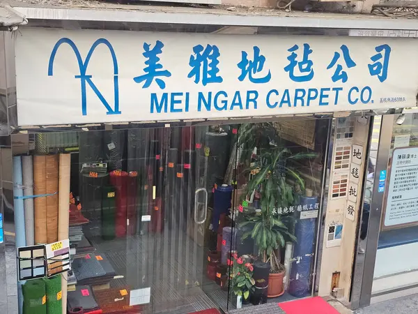 Hong Kong, Çin - 6 Haziran 2025: Mei Ngar Halı Şirketi girişi, çeşitli renkli halı ruloları ve ev dekorasyonu için döşeme örnekleri sergileniyor.