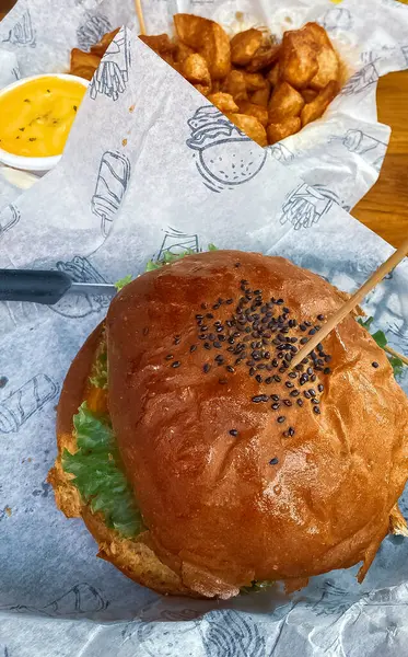Lezzetli burger. Salata, et, peynir ve soslu taze hamburger ve patates kızartması..
