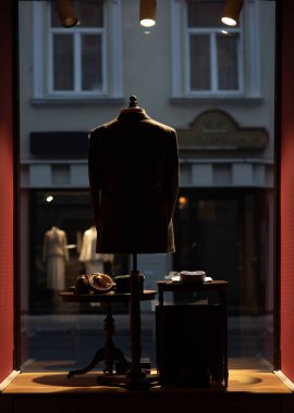 Gecenin geç saatlerinde küçük bir mağazanın vitrininde duran bir manken silueti. Dikey fotoğraf. Dışarıda bir şehir sokağı görülebilir. Yüksek kalite fotoğraf. Litvanya ülkesi