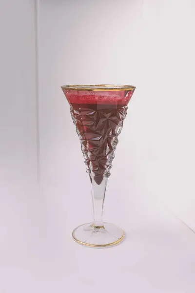 Beetroot juice in a beautiful glass with a gold rim. High quality photo