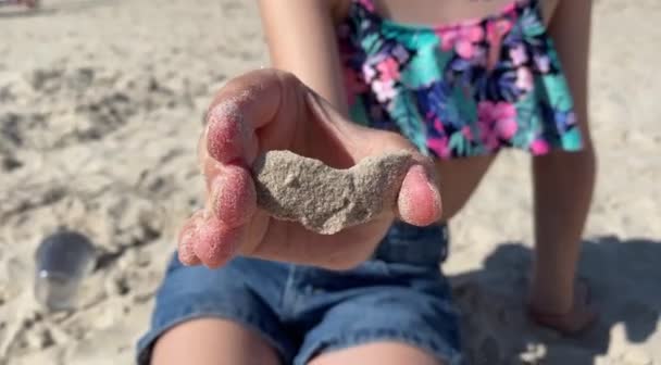 彼女は手で砂から小さな心臓をこすっている 高品質のフルHd映像 — ストック動画