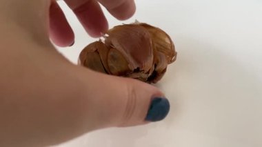 Beyaz bir tabakta siyah mayalanmış sarımsak. Yüksek kalite 4k görüntü