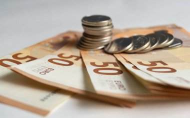 Avro banknotları yakın plan. Yakın plan 50 Euro. (Avrupa Birliği para birimi). Banknotların üstünde madeni paralar var..