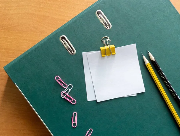 Blank note sticks on clip pencils and paper clips on document folder