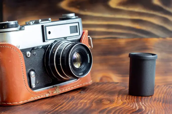 Vintage film camera and film on a wooden background