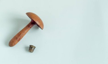 Beyaz arka planda eski bir yüksük, ahşap bir dikiş makinesi.