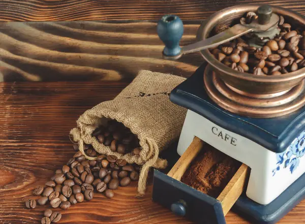 Vintage coffee grinder, coffee beans on wooden background