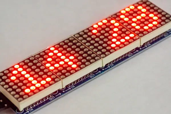 LED matrisi 8x8. İzole edilmiş beyaz arkaplan üzerindeki LED matrislerin bileşimi. LED matrisi 8x8 üzerindeki saat
