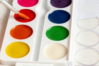 Boya fırçaları ve renkli boyalar. Beyaz bir arkaplanda.