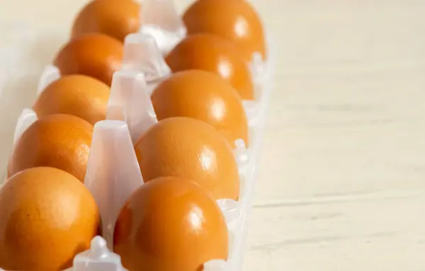 10 'luk pakette sarı yumurtalar açık arkaplanda