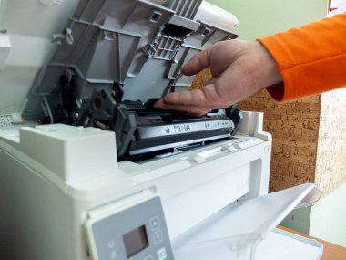 Servis elemanı şarjörü fotokopi makinesine, lazer yazıcıyı da ofise yerleştirir. Ofis kavramı.