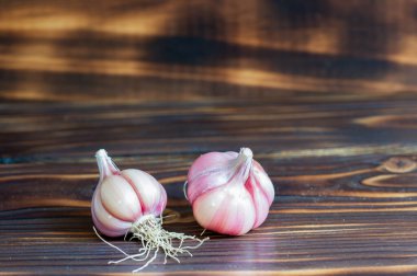 Ahşap bir arka planda duran sarımsak yakın plan.