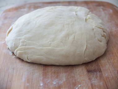 Pişirme hamuru tahtanın üzerine serilmiştir.