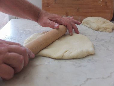 Pişirme hamuru tahtanın üzerine serilmiştir.