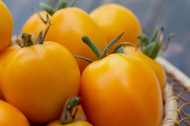 Orange, yellow tomatoes in a wicker basket clipart