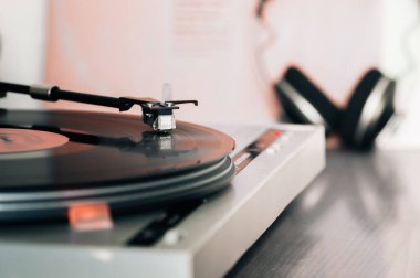 Kulaklıklar ve vinil pikabın yakın çekimi vinil plaktaki kartuşun yakın çekimi, analog retro müzik, vinil disk koleksiyonu, antika ekipmanlar.