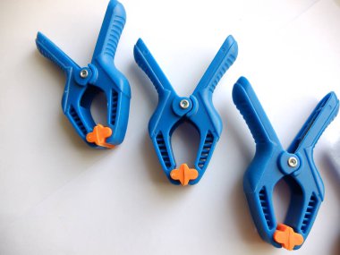 Plastik kelepçe beyaz arkaplanda izole edilmiş. El işi, marangozluk ve fotoğrafçılık için klemp ekipmanları. Üst görünüm.