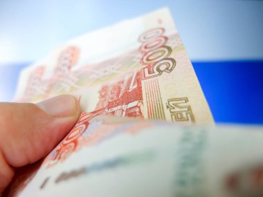 Rus banknotları yakın planda. Arka planda ulusal bayrak