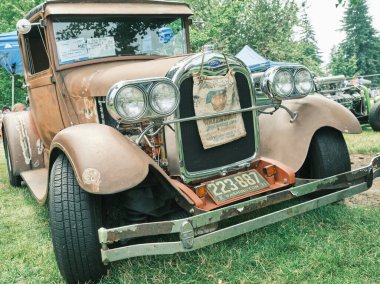 Auburn WA USA, 4 Temmuz 2025 - Klasik bir 4 Temmuz geleneği için klasik ulaşım meraklıları Les Gove Park 'ın antika arabalarına, kamyonlarına ve motosikletlerine hayran kalabilirler