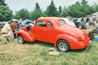 Auburn WA USA, 4 Temmuz 2025 - Klasik bir 4 Temmuz geleneği için klasik ulaşım meraklıları Les Gove Park 'ın antika arabalarına, kamyonlarına ve motosikletlerine hayran kalabilirler