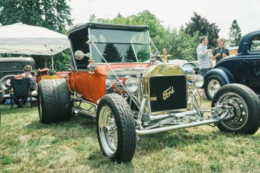 Auburn WA USA, 4 Temmuz 2025 - Klasik bir 4 Temmuz geleneği için klasik ulaşım meraklıları Les Gove Park 'ın antika arabalarına, kamyonlarına ve motosikletlerine hayran kalabilirler