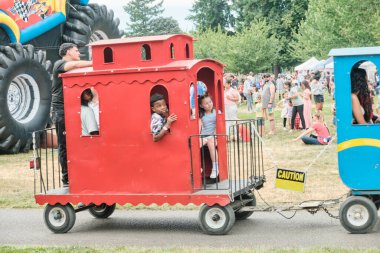 Auburn WA USA, 4 Temmuz 2025 - Çocuklar için eğlence, hafta sonu için park yolları boyunca renkli at arabalarıyla buharlı trene binmektir.
