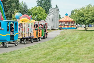 Auburn WA USA, 4 Temmuz 2025 - Çocuklar için eğlence, hafta sonu için park yolları boyunca renkli at arabalarıyla buharlı trene binmektir.