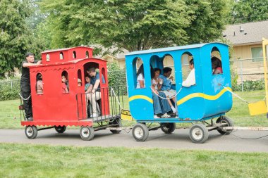 Auburn WA USA, 4 Temmuz 2025 - Çocuklar için eğlence, hafta sonu için park yolları boyunca renkli at arabalarıyla buharlı trene binmektir.