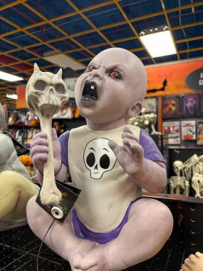 Woodinville, WA USA, 4 Ağustos 2025 - Cadılar Bayramı eşyaları, maskeler, kostümler, iskeletler, figürler, şapkalar, kafatasları, kemikler, mezar taşları olan vitrinler. Cadılar Bayramı konsepti. Dikey fotoğraf